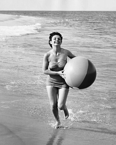 Woman running with beach ball