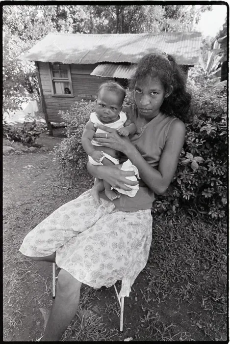 Framed Print : Woman Seated with Baby in Front of Home Framed Print : Woman Seated with Baby in Front of Home