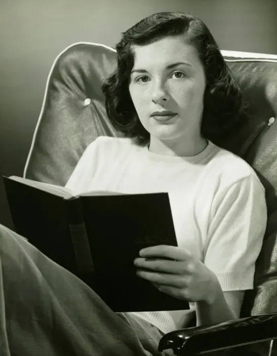 Framed Print : Woman sitting on armchair, holding book, (B&W), (Portrait) Framed Print : Woman sitting on armchair, holding book, (B&W), (Portrait)