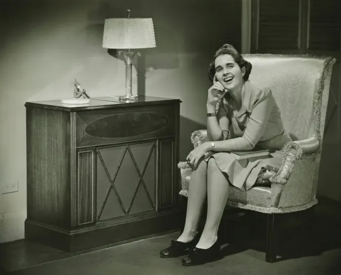 Framed Print : Woman sitting in armchair, smiling, (B&W) Framed Print : Woman sitting in armchair, smiling, (B&W)