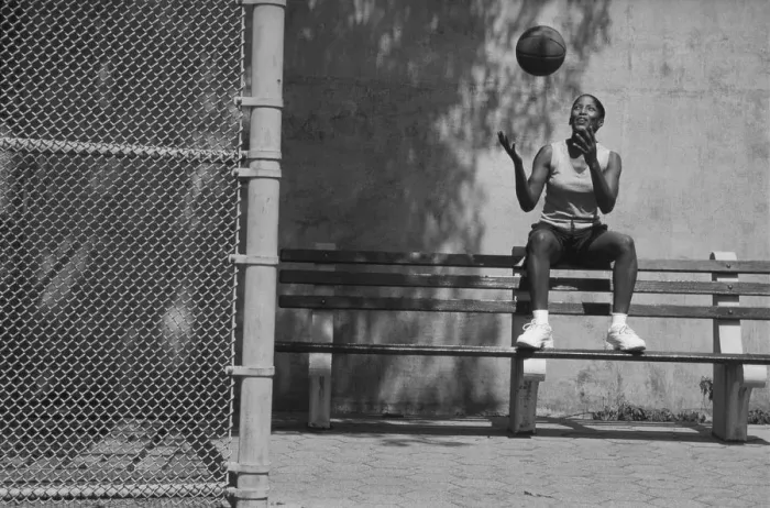 Framed Print : Woman sitting on bench tossing basketball in air (B&W) Framed Print : Woman sitting on bench tossing basketball in air (B&W)