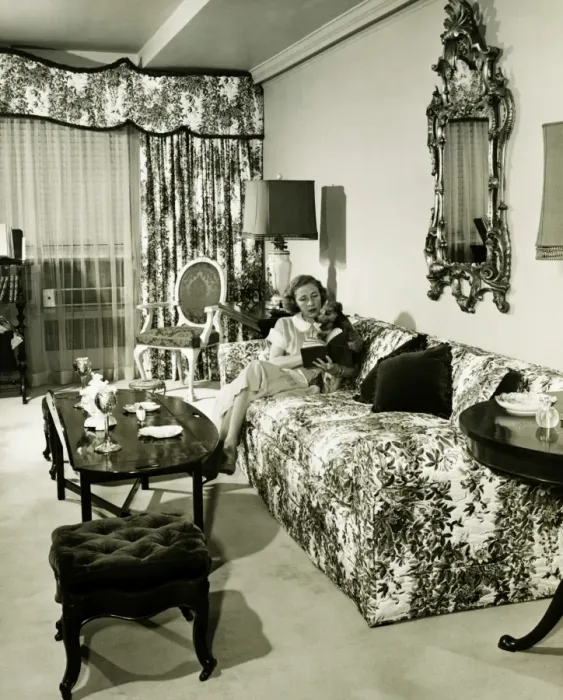 Framed Print : Woman sitting on couch in opulent living room, reading book, (B&W) Framed Print : Woman sitting on couch in opulent living room, reading book, (B&W)