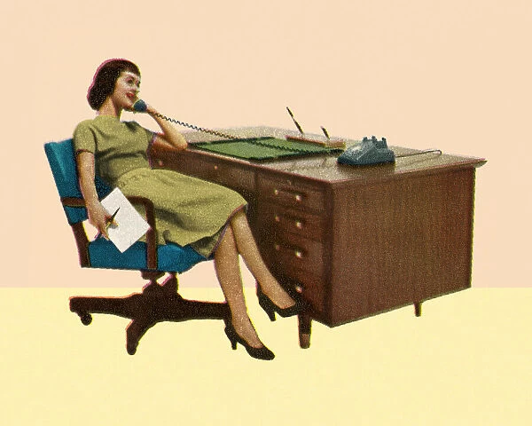 Woman Sitting at Desk Talking on Phone