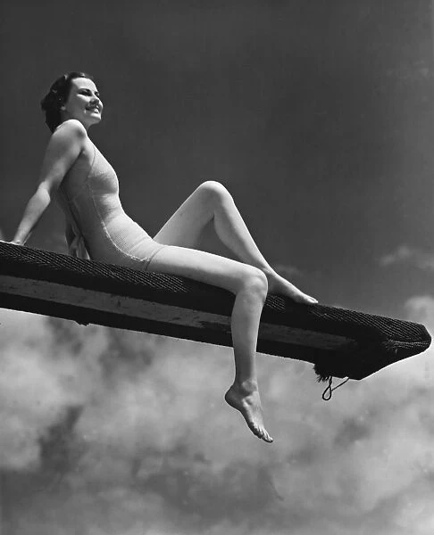 Woman sitting on divingboard