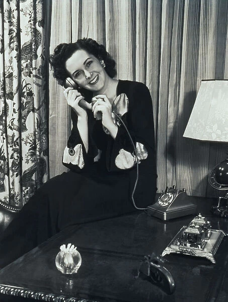 Woman Sitting in Lounge, Talking on Telephone