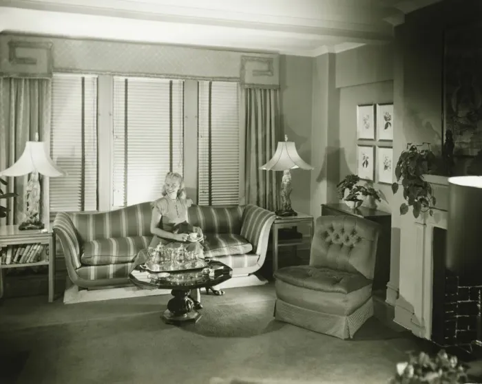 Framed Print : Woman sitting on sofa in stylish living room, (B&W) Framed Print : Woman sitting on sofa in stylish living room, (B&W)