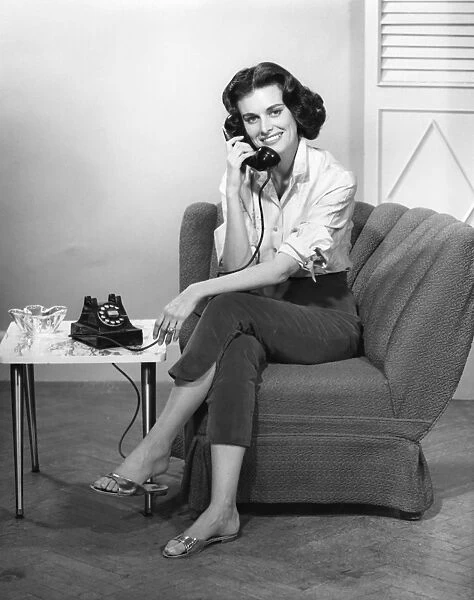 Woman sitting & talking on telephone