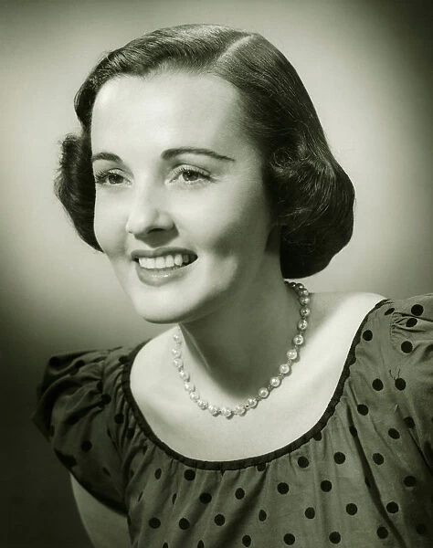 Woman in spotted dress posing in studio, (B&W), (Close-up), (Portrait)