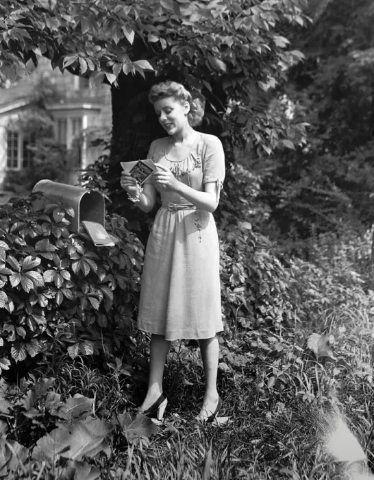 Framed Print : Woman standing at mailbox, looking at letters, (B&W) Framed Print : Woman standing at mailbox, looking at letters, (B&W)