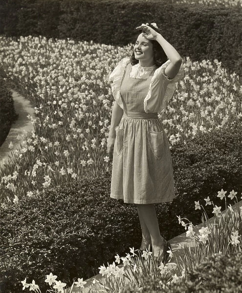 Woman standing among spring daffodils