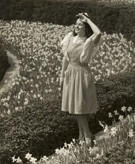 Framed Print : Woman standing among spring daffodils