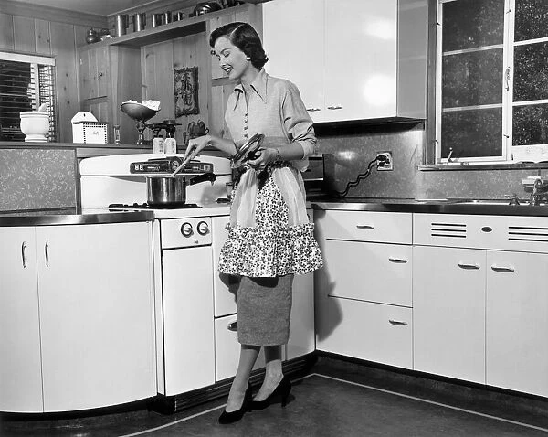 Woman stirring pot at stove