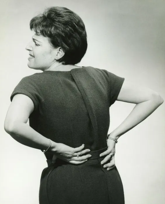 Framed Print : Woman in studio grasping back in pain, (B&W) Framed Print : Woman in studio grasping back in pain, (B&W)