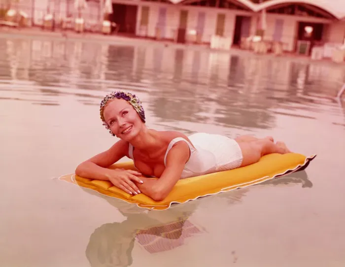 Framed Print : Woman in swimming pool reclining on inflatable raft, wearing bathing cap, smiling Framed Print : Woman in swimming pool reclining on inflatable raft, wearing bathing cap, smiling