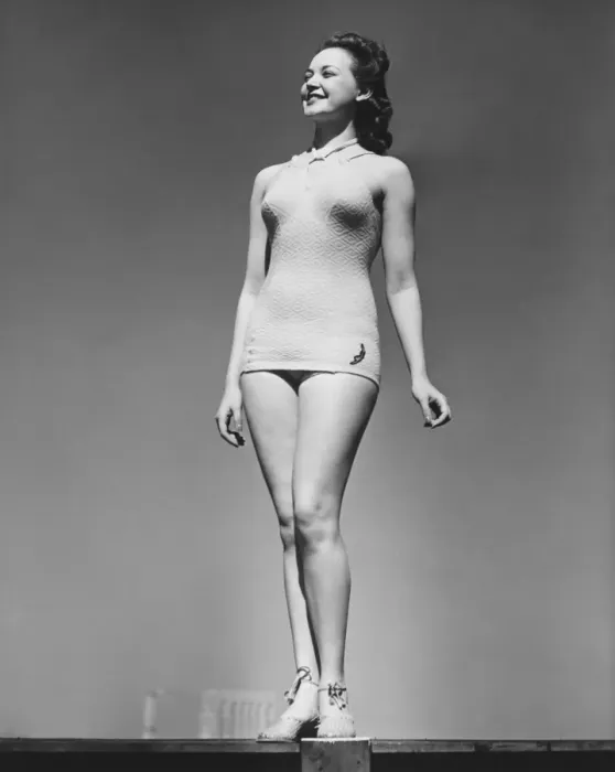 Framed Print : Woman in swimsuit posing in studio (B&W), low angle view Framed Print : Woman in swimsuit posing in studio (B&W), low angle view
