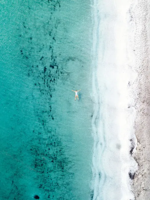 Framed Print : Woman takes a bath and floats in a turquoise sea. Stintino, Sardinia, Italy. Aerial view Framed Print : Woman takes a bath and floats in a turquoise sea. Stintino, Sardinia, Italy. Aerial view