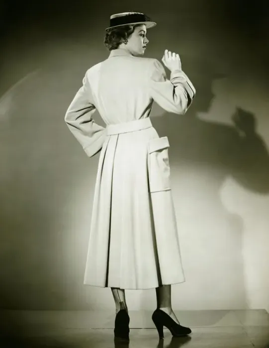 Framed Print : Woman in trench coat and hat posing in studio (Rear view), (B&W) Framed Print : Woman in trench coat and hat posing in studio (Rear view), (B&W)