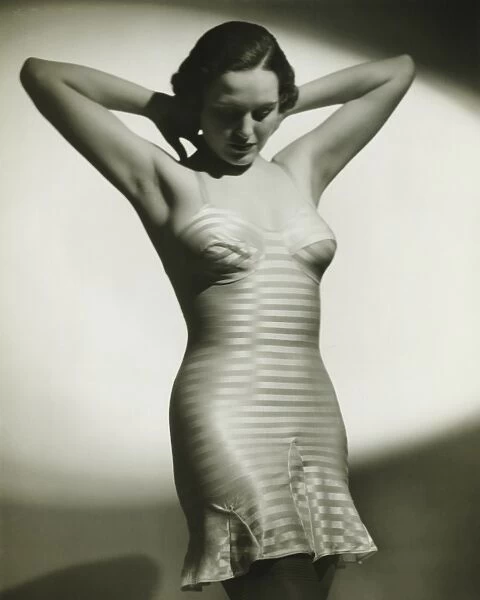 Woman in underskirt posing in studio, (B&W), portrait