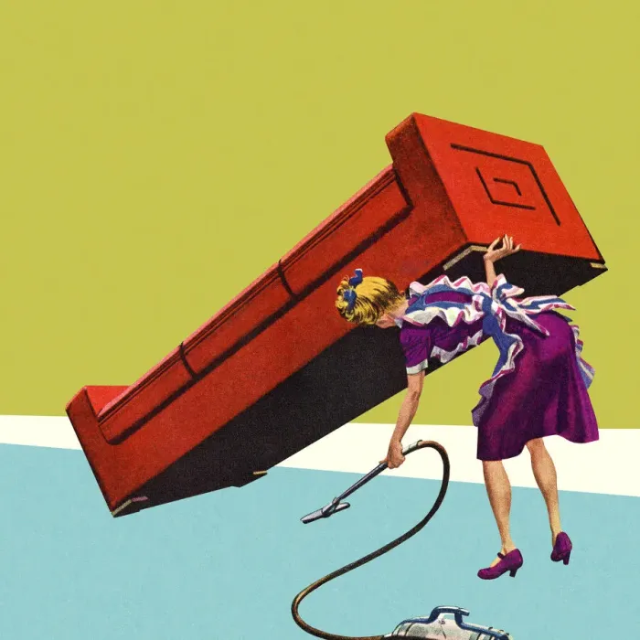 Framed Print : Woman Vacuuming Under a Sofa Framed Print : Woman Vacuuming Under a Sofa