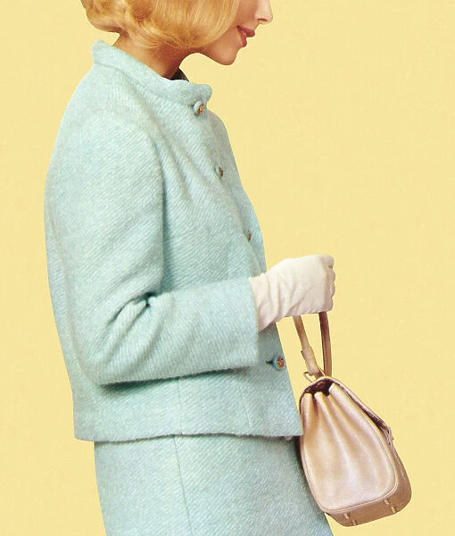 A woman in vintage blue suit holding a purse