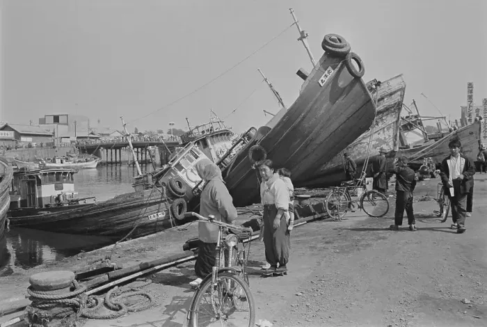 Framed Print : Woman W / Bike Looks Washed-Aground Boats