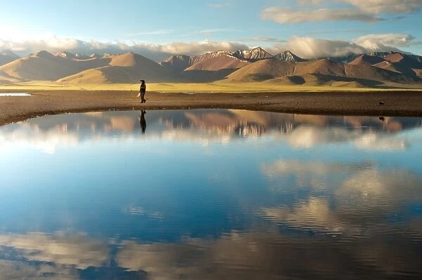 Woman walk along Namtso lake in Tibet