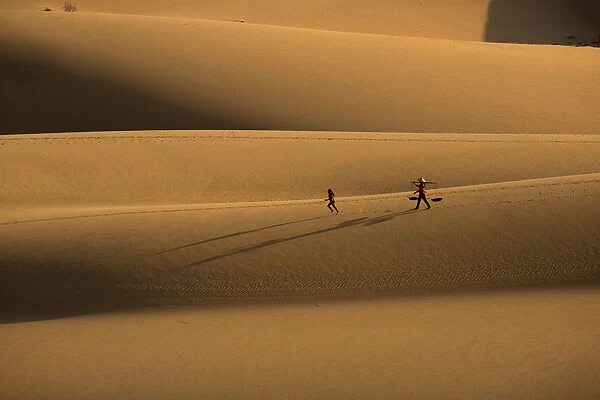 Woman walking, girl running on sanddune