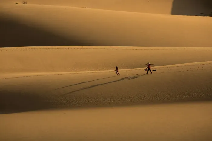 Framed Print : Woman walking, girl running on sanddune Framed Print : Woman walking, girl running on sanddune