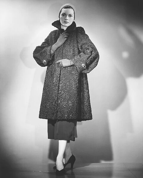 Woman wearing fur coat posing in studio (B&W)