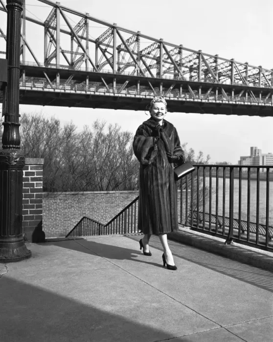 Framed Print : Woman wearing fur coat, standing by bridge (B&W) Framed Print : Woman wearing fur coat, standing by bridge (B&W)