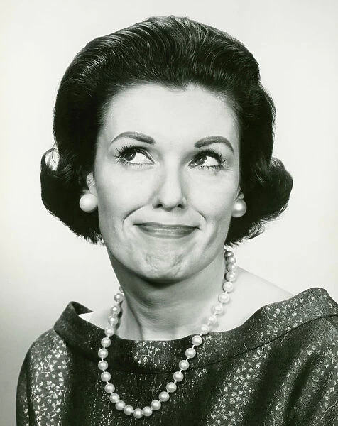 Woman wearing pearls looking away, posing in studio, (B&W), (Portrait)