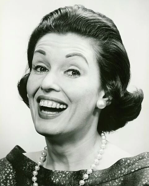 Woman wearing pearls smiling (B&W), (Portrait)