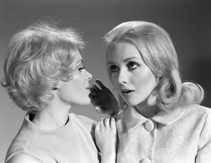 Framed Print : Woman whispering secret into another woman's ear Framed Print : Woman whispering secret into another woman's ear