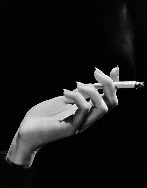 Womans hand holding lit cigarette
