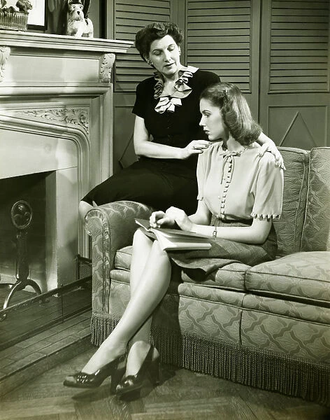 Two women sitting on couch, discussing, (B&W)
