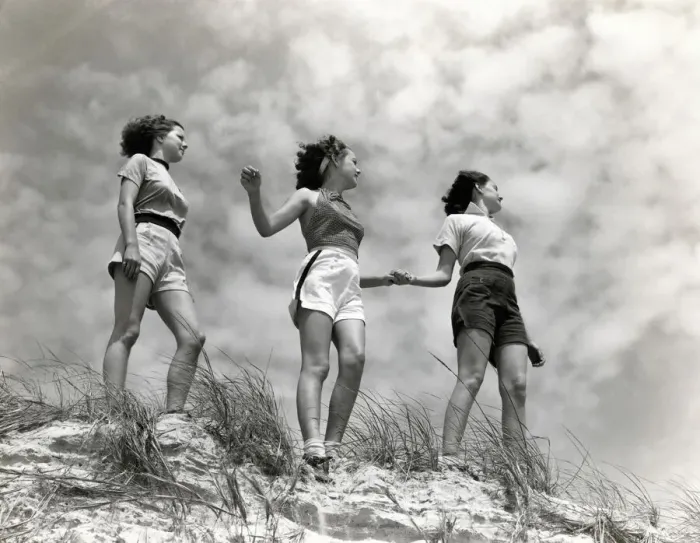 Framed Print : Three women standing on beach, holding hands, smiling. (Photo by H Framed Print : Three women standing on beach, holding hands, smiling. (Photo by H