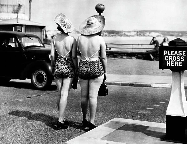 Women In Swimwear. Two women cross the road to the beach in Porthcawl, South Wales