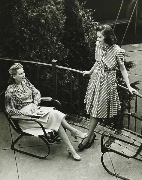 Two women talking on balcony, (B&W), elevated view