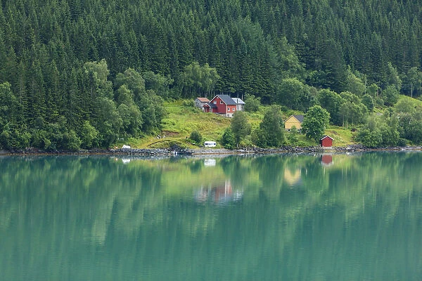 Wooden farmhouses on hill by fjord, Olden, Norway