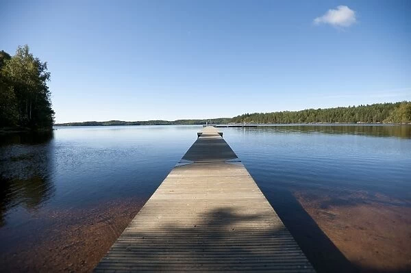 Wooden landing stage leading towards a vast lake, Sweden, Europe
