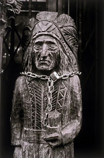 A wooden statue of a Native American