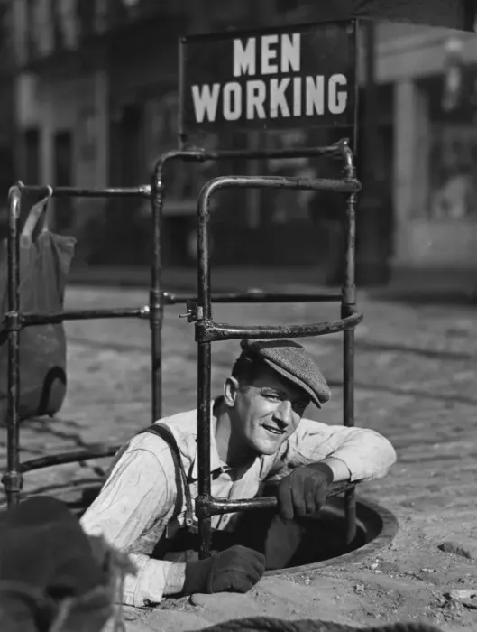 Framed Print : Worker climbing into manhole