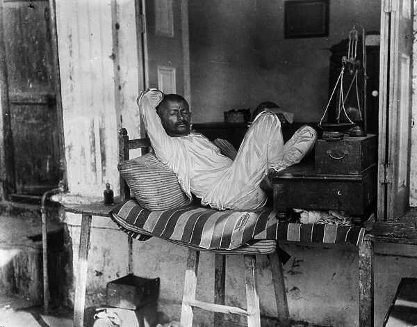 Worn Out. circa 1930: A Bombay shopkeeper snatches a rest