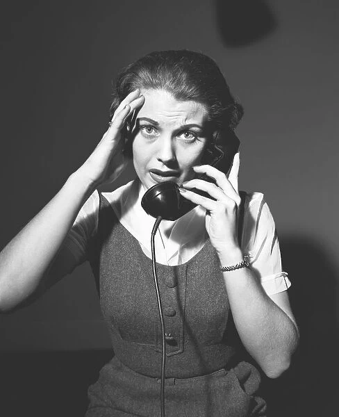 Worrying woman talking on phone, (B&W), portrait