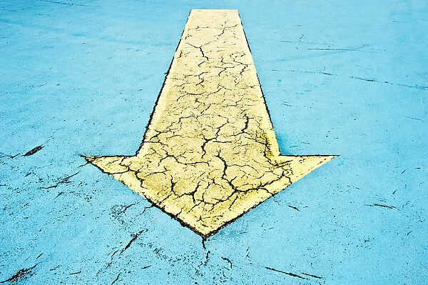 Yellow arrow on blue asphalt