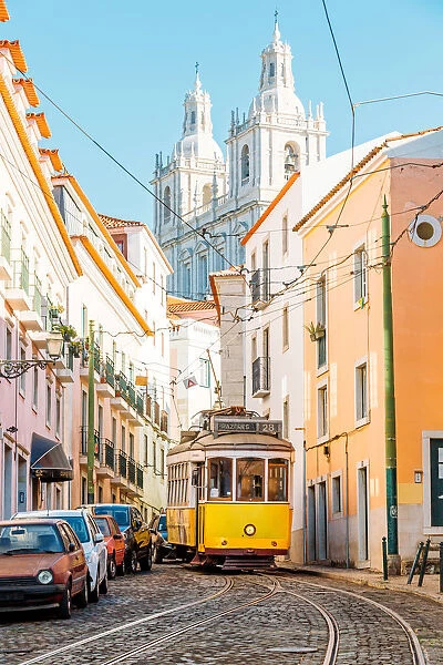 Yellow tram on the narrow street of Alfama district in Lisbon, Portugal