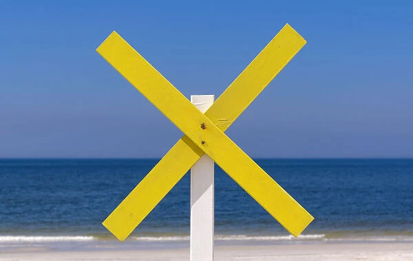 A yellow wooden cross marks a shoal near the shore at the beach, near Kampen, Sylt, Schleswig-Holstein, Germany