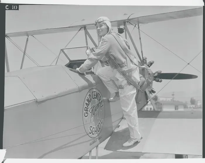 Framed Print : Young Aviatrix Climbing into Airplane Framed Print : Young Aviatrix Climbing into Airplane