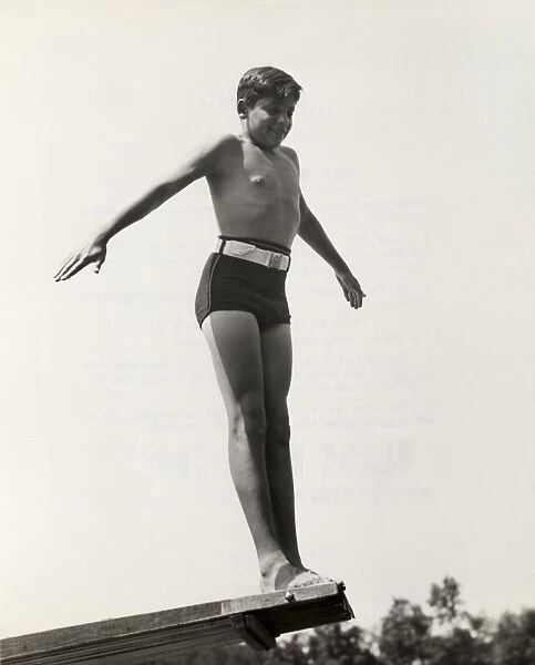 Young boy at end of diving board
