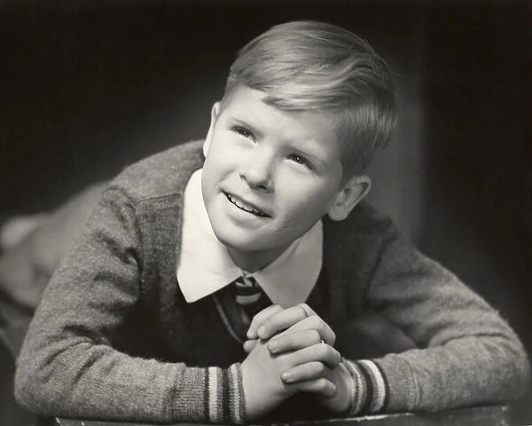 Young boy with his hands folded